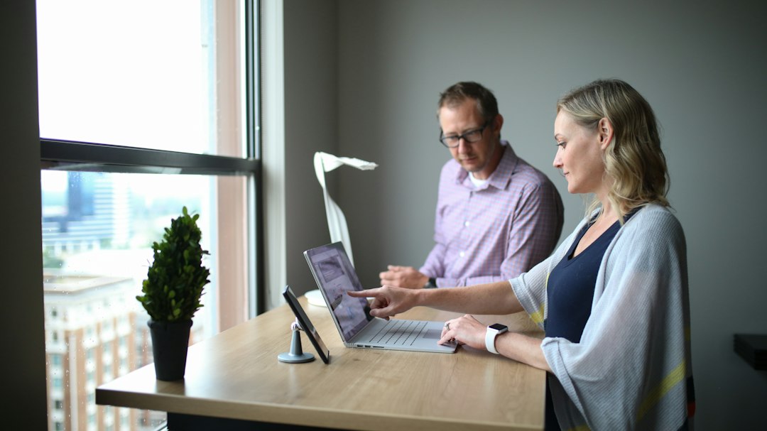 IT support professionals working together on a laptop in an office